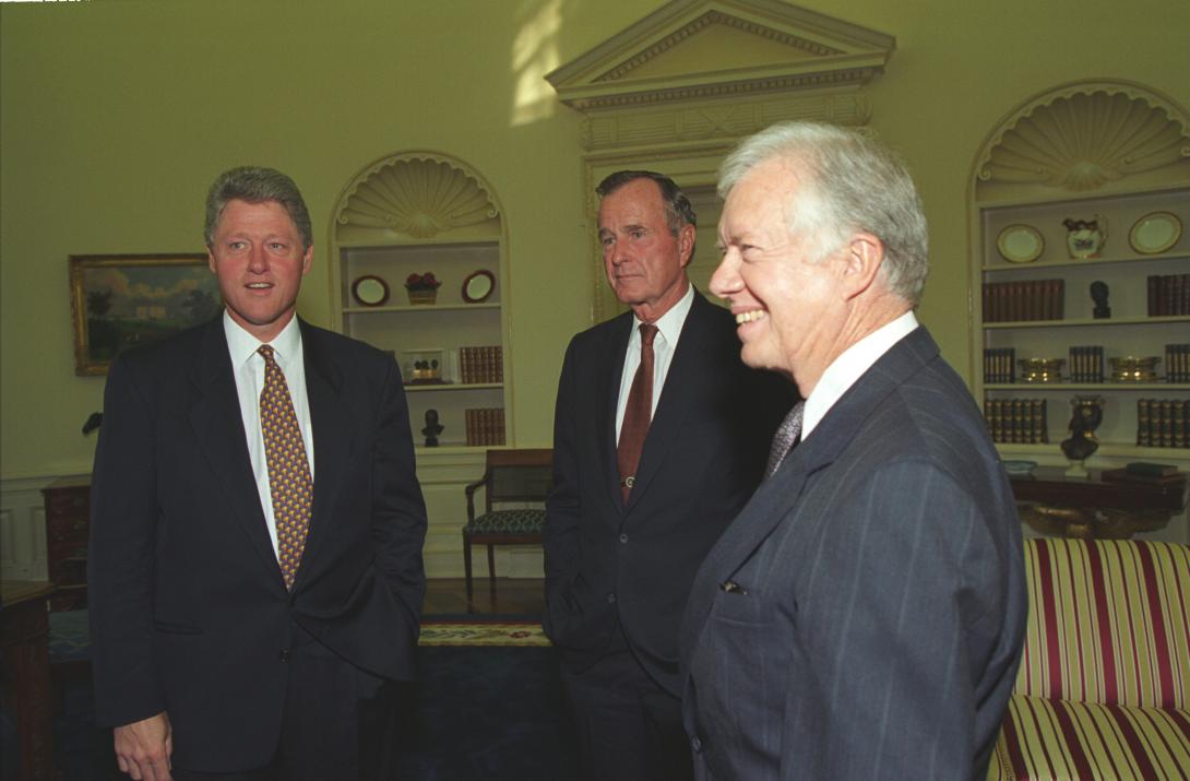 President Clinton talking with former President George H.W. Bush and former President Jimmy Carter in the Oval Office. The President and former Presidents gather following the Middle East Peace Agreement signing ceremony, September 13, 1993.